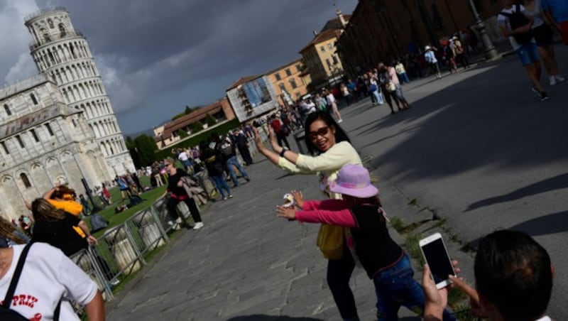 Ein beliebtes Fotomotiv für Touristen: Der oder die Abgebildete stützt mit seinen Händen scheinbar den Turm ab. (Bild: AFP)