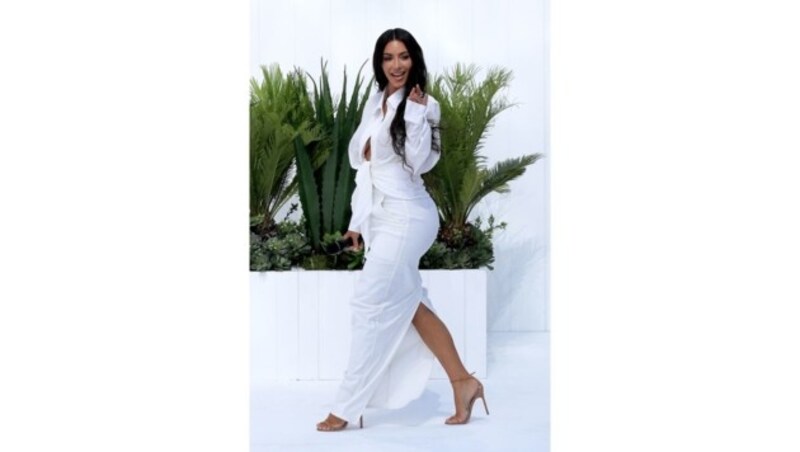 Kim Kardashian bei einem Fashion-Event in weißer, geknoteter Bluse zum engen weißen Rocke. (Bild: www.PPS.at)