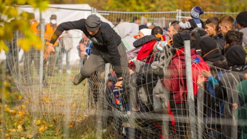 Ein Flüchtling springt im Oktober 2015 an der slowenisch-österreichischen Grenze über einen Zaun. (Bild: AFP)