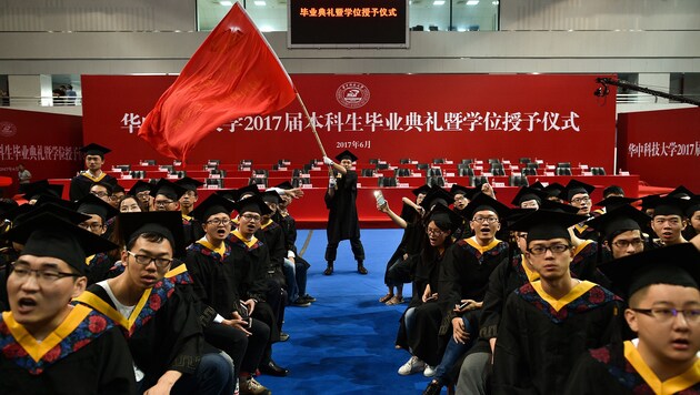 Ein Absolvent der Huazhong University of Science and Technology schwenkt stolz eine Flagge. (Bild: AFP)
