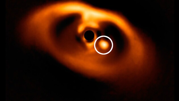 Der junge Planet PDS 70b (weiß markiert) in der Staubscheibe um sein Zentralgestirn (Bild: ESO/A. Müller et al.)