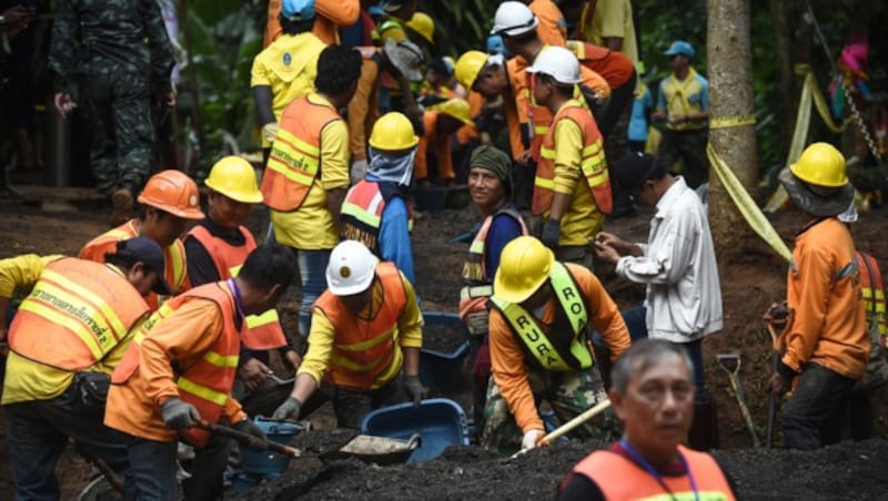 Arbeiter reparieren die Straße, die zur Höhle führt, wo das Fußballteam und der Trainer eingeschlossen sind. (Bild: AFP )