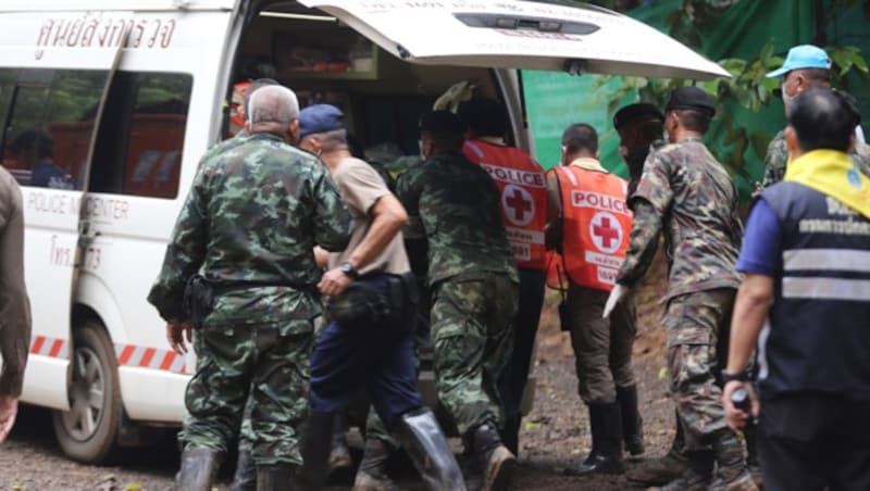 Einer der ersten vier Buben, die aus der Höhle befreit wurden, wird in einem Krankenwagen abtransportiert. (Bild: AFP)