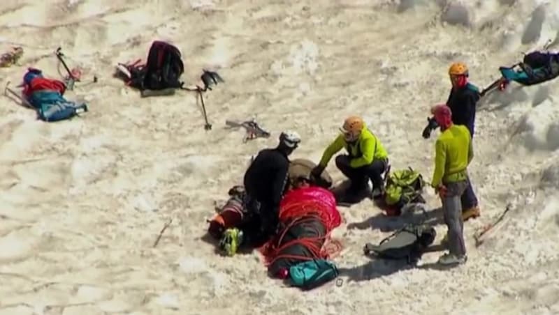 Die Bergretter warten auf die Ankunft des Hubschraubers. (Bild: YouTube.com)