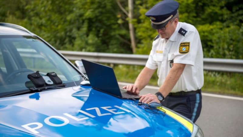 Ein Beamter bedient am Grenzübergang Kirchdorf ein mobiles Fingerabdruck-Erfassungssystem. (Bild: APA/dpa/Lino Mirgeler)