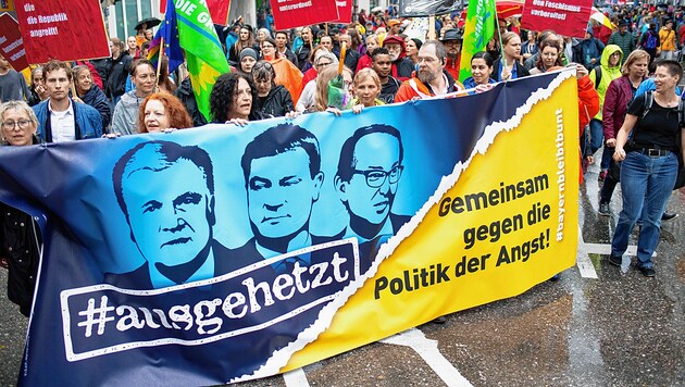Für diese Demonstranten in München ist klar, wer eine „Politik der Angst betreibt“: Auf dem Banner sind CSU-Chef und Innenminister Horst Seehofer, Bayerns Ministerpräsident Markus Söder und CSU-Landesgruppenchef Alexander Dobrindt abgebildet. (Bild: EPA)