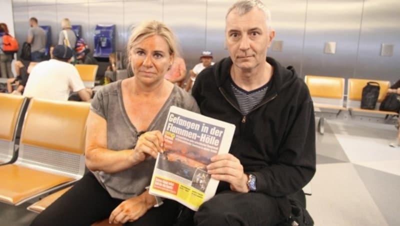 Unsere Leser Helga und Thomas Haase aus Niederösterreich bekamen die Tragödie als Urlauber in Athen hautnah mit. Nach der Landung in Wien-Schwechat informierten sie sich gleich in der druckfrischen „Krone“. (Bild: Schiel Andreas)