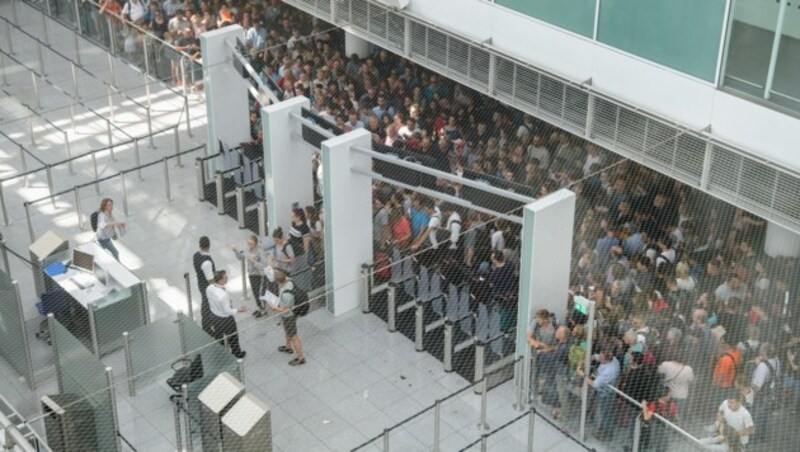 Lange Schlangen haben sich vor den wieder geöffneten Sicherheitskontrollen im Terminal 2 gebildet. (Bild: APA/dpa/Matthias Balk)