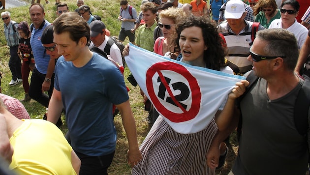 Eine Attac-Aktivistin lüftet ihre Protest-Schürze neben Kanzler Kurz. (Bild: (c) Attac)