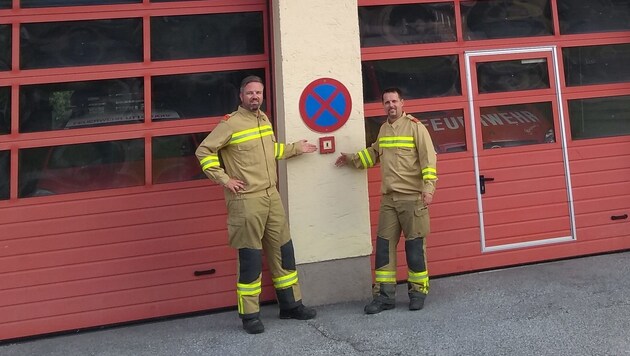 Kommandant Lukas Fritzenwanger (rechts) und Kommandant-Stellvertreter Florian Schett vor dem Feuerwehrhaus Uttendorf beim Brandmelder, der vom Ersthelfer betätigt wurde. (Bild: Feuerwehr Uttendorf)