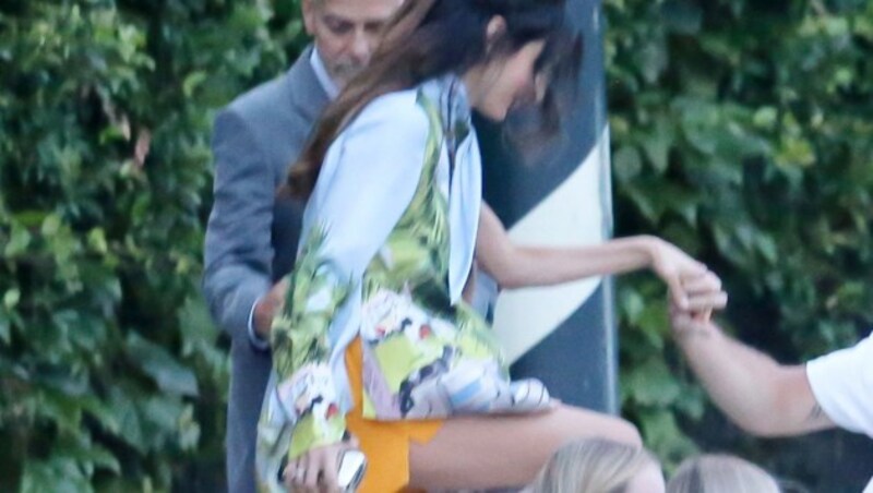 Amal Clooney in orangen Shorts und einer asymmetrischen Tunika mit Kubaprint auf dem Weg zum Dinner mit Ehemann George Clooney. (Bild: www.PPS.at)