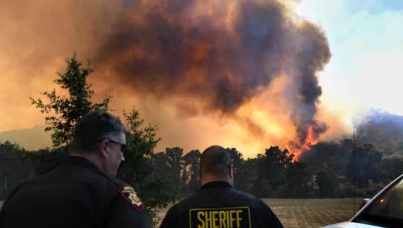 Die Feuerwalze gewann durch starke Winde an Geschwindigkeit. Die Einsatzkräfte stehen rund um die Uhr im Einsatz. (Bild: APA/AFP/Mark RALSTON)