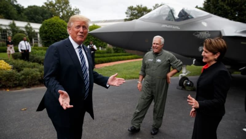 US-Präsident Donald Trump spricht mit dem CEO von Lockheed Martin, Marilyn Hewson (re.), und einem Testpiloten beim „Made in America Product Showcase“. Im Hintergrund ist eine F-35 zu sehen. (Bild: AP)