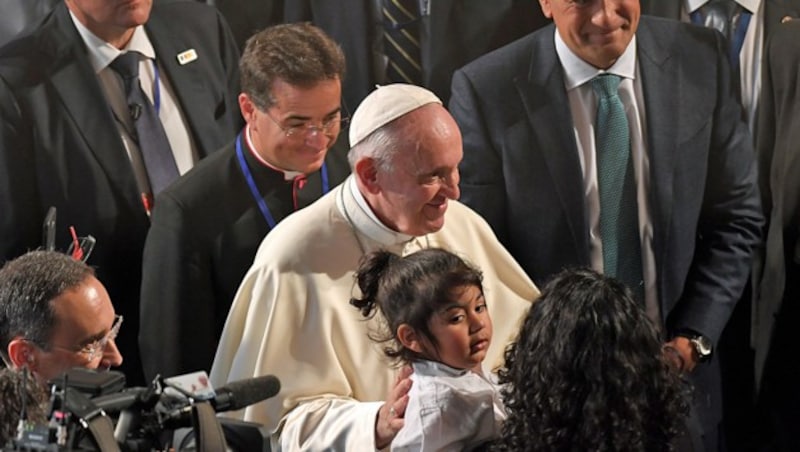 Papst Franziskus verabschiedet sich nach seiner Rede von einem kleinen Mädchen und dessen Mutter. (Bild: APA/AFP/TIZIANA FABI)