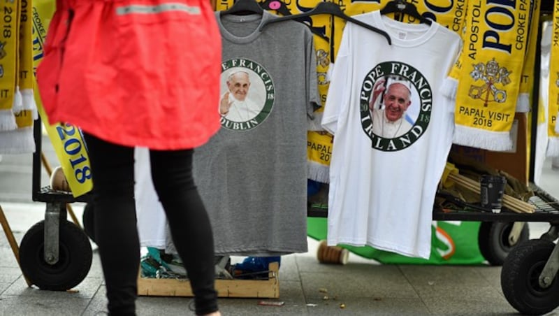 Jeder Besuch des Papstes ist auch mit Fan-Produkten verbunden. Hier können sich Interessierte „heilige“ T-Shirts und Schals besorgen. (Bild: APA/AFP/Ben STANSALL)