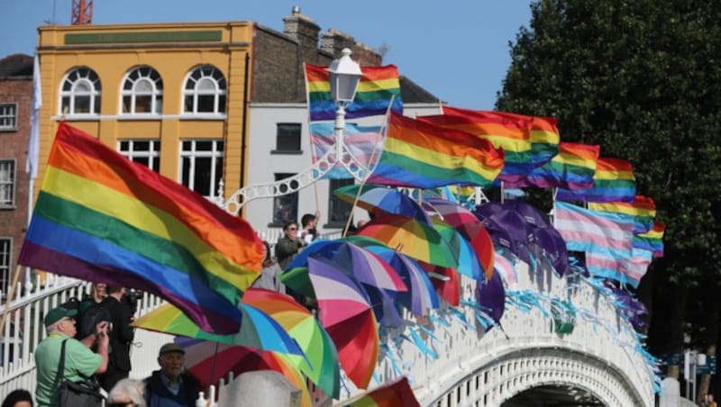 Mit Regenbogenfahnen und blauen Schleifen machen diese Demonstranten in Irland auf die Missbrauchsopfer aufmerksam. (Bild: AP)