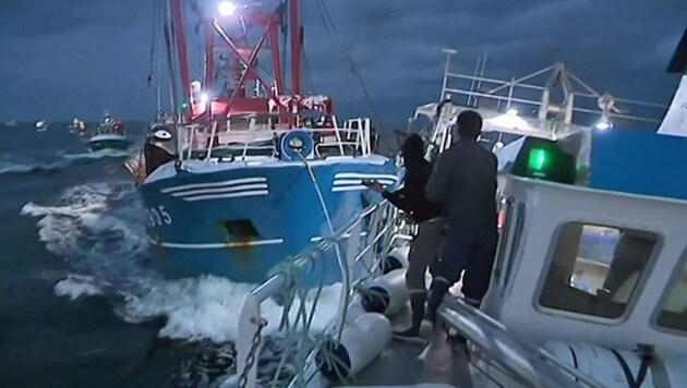 Diese Aufnahme zeigt französische Fischer, die ein britisches Schiff abdrängen und mit Steinen bewerfen. (Bild: twitter.com)