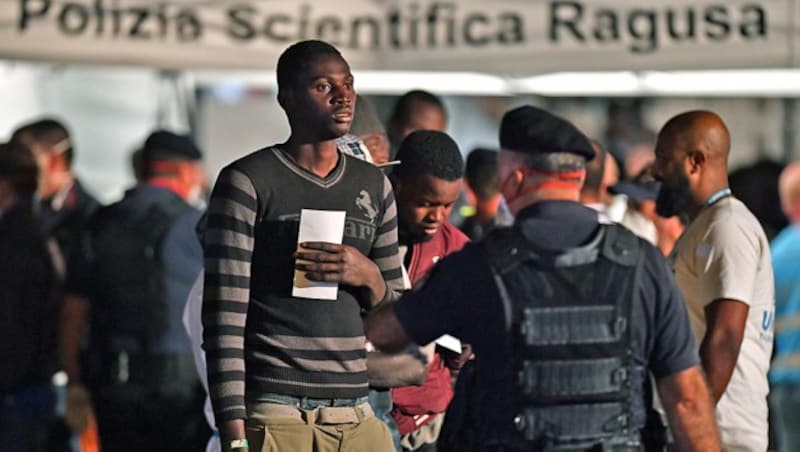 Migranten, die an Bord des Küstenwachenschiffs Diciotti nach langem Ausharren an Deck doch in Italien ans Festland durften. (Bild: APA/AFP/GIOVANNI ISOLINO)