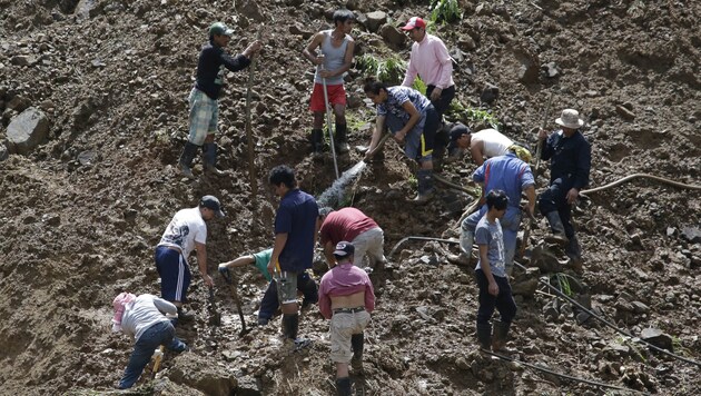 Bergbauarbeiter graben teils mit bloßen Händen nach ihren Kollegen. (Bild: AP)