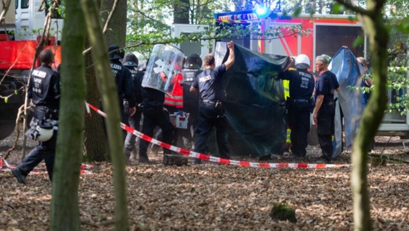 Polizisten und Notärzte bringen den Blogger nach dem 15-Meter-Absturz zu einem Krankenwagen. (Bild: APA/dpa/Christophe Gateau)