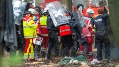 Polizisten und Notärzte bringen den Blogger nach dem 15-Meter-Absturz zu einem Krankenwagen. (Bild: APA/dpa/Christophe Gateau)