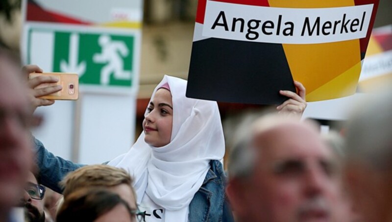 Ein muslimische Anhängerin von Bundeskanzlerin Angela Merkel mit Kopftuch (Bild: APA/dpa/Oliver Berg)