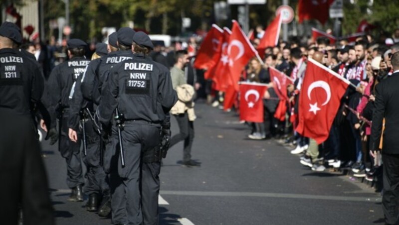 Polizisten und Menschen mit türkischen Fahnen säumten am Samstag die Straßen von Köln. (Bild: APA/AFP/SASCHA SCHUERMANN)