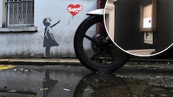 Oktober 2018: Street-Art-Künstler Banksy wollte sein während einer Auktion in London teilweise zerstörtes Kunstwerk eigentlich vollständig schreddern. (Bild: AFP, youtube.com, krone.at-Grafik)