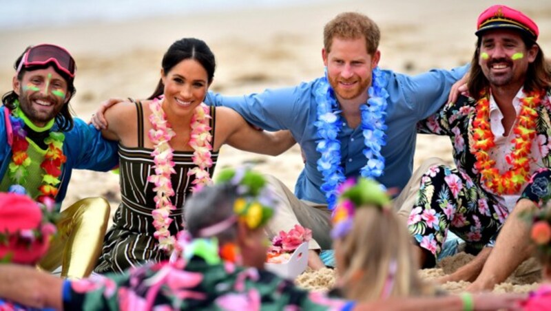 Mit Vertretern der Gruppe OneWave setzten sich Meghan und Harry auch in den Sand. (Bild: AP)