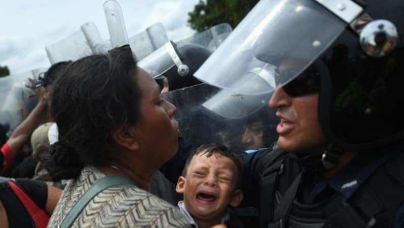 Mexikanische Polizisten versuchen, die Flüchtlinge vor dem Übertritt in ihr Land zu hindern. (Bild: AFP)