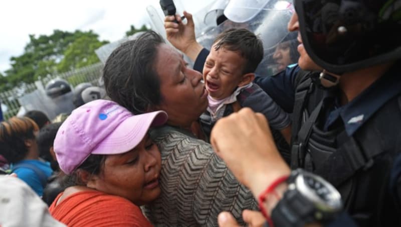 Mexikanische Polizisten versuchen, die Flüchtlinge vor dem Übertritt in ihr Land zu hindern. (Bild: AFP or licensors)