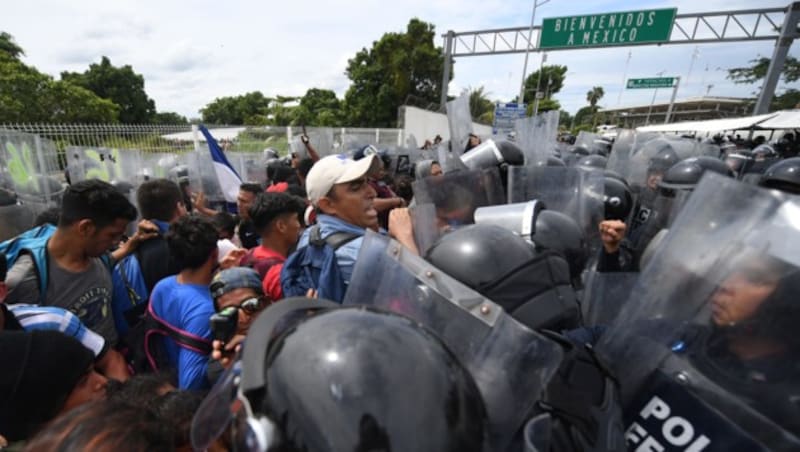 Mexikanische Polizisten versuchen, die Flüchtlinge am Übertritt in ihr Land zu hindern. (Bild: AFP)