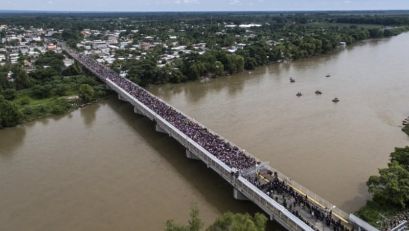 Diese Luftaufnahme zeigt den Flüchtlingsstrom nach dem Überwinden der Grenzzäune und die mexikanischen Straßensperren auf der Grenzbrücke. (Bild: AFP)