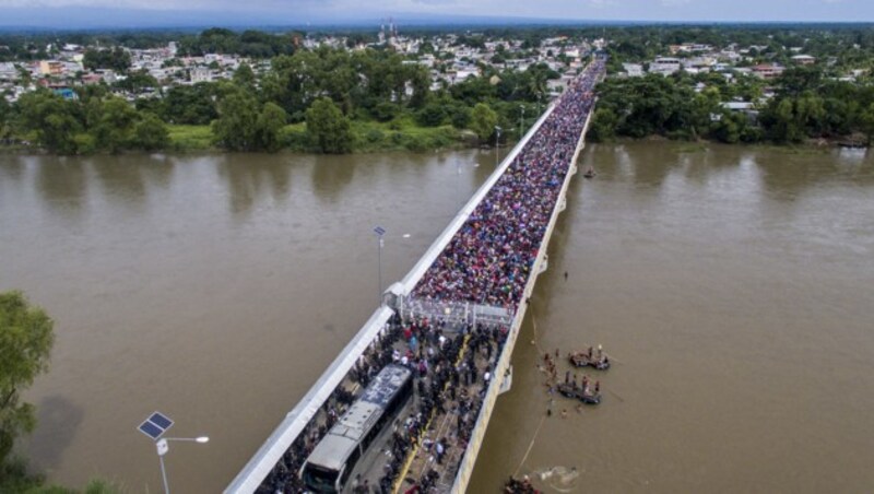 Diese Luftaufnahme zeigt den Flüchtlingsstrom nach dem Überwinden der Grenzzäune und die mexikanischen Straßensperren auf der Grenzbrücke. (Bild: AFP)