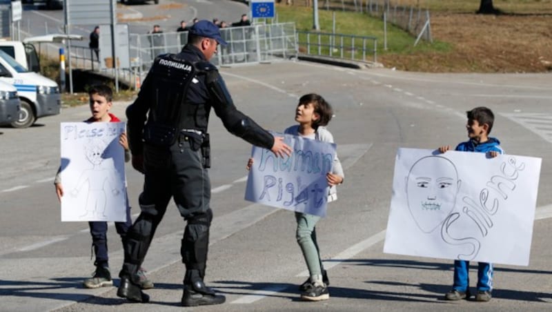 Kinder machen mit Plakaten auf ihre Situation aufmerksam. (Bild: AP)