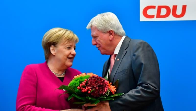 Angela Merkel überreicht Hessens Ministerpräsidenten Volker Bouffier Blumen. (Bild: AFP )