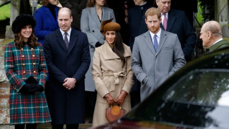 Herzogin Kate, Prinz William, Prinz Harry und seine zu diesem Zeitpunkt noch Verlobte Meghan Markle warteten am Weihnachtstag 2017 vor der St.-Mary-Magdalene-Kirche in Sandringham auf die Ankunft von Prinz Philip und Königin Elizabeth. (Bild: Alastair Grant / AP / picturedesk.com)