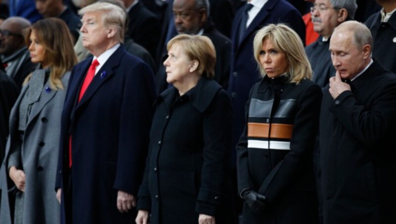 Donald Trump, Angela Merkel und Wladimir Putin in Paris (Bild: AP)