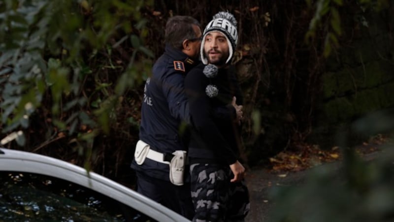 Ein Bewohner wird bei der Polizeiaktion in Rom gleich mitgenommen. (Bild: AP)