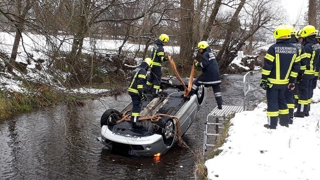 Der Wagen des Unfalllenkers landete am Dach im Bach. Der 34-Jährige wurde leicht verletzt, befreite sich selbst. (Bild: FF Frankenburg)