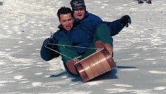 Gemeinsamer Rodelausflug von Schwarzenegger und Bush senior auf dem Präsidenten-Landsitz Camp David im Jahr 1991 (Bild: Arnold Schwarzenegger, krone.at-Grafik)