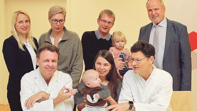 Mutter Christine Raffelsberger mit Sohn Jan (vier Monate) zwischen Primar Wolfgang Arzt (links) und Primar Gerald Tulzer (rechts). (Bild: Christoph Gantner)