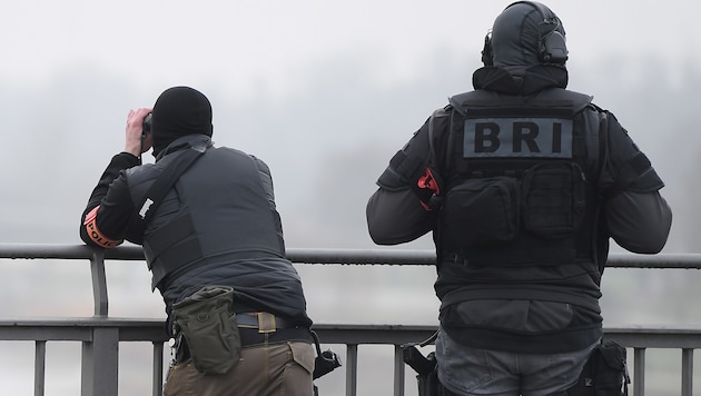 Französische Polizisten blicken über die Grenze nach Deutschland. (Bild: APA/AFP/Frederick FLORIN)