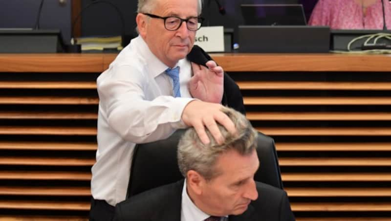 Nicht nur Frauenhaare im Visier: Hier zerstrubbelt Juncker die Frisur von EU-Haushaltskommissar Günther Oettinger. (Bild: AFP)