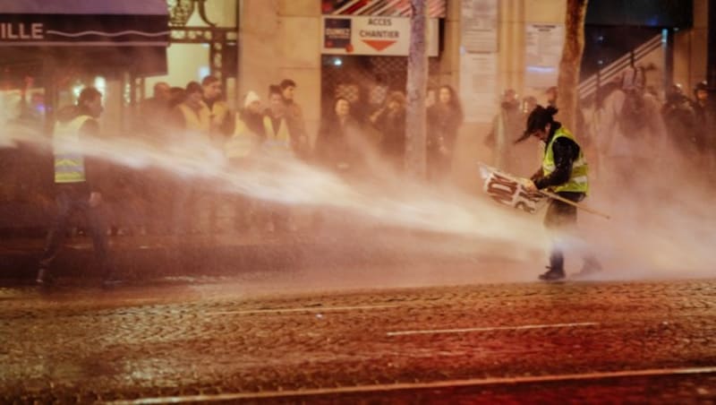 Ein Demonstrant kämpft sich gegen den Strahl eines Wasserwerfers vor. (Bild: AP)