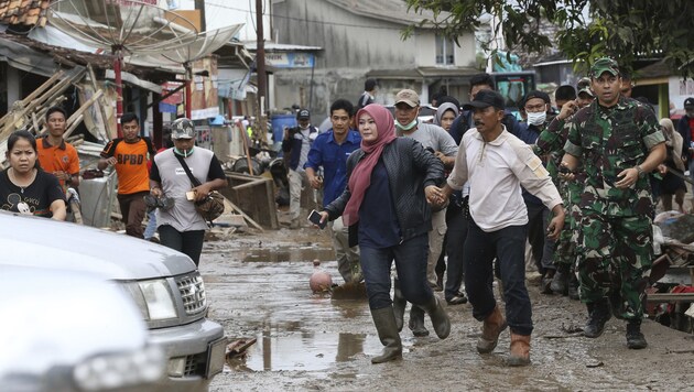 Bewohner von Sumber Jaya flüchten nach einer Falschmeldung über einen herannahenden Tsunami in höher gelegene Teile ihres Dorfes. (Bild: AP)