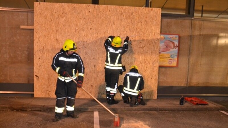 Feuerwehrleute vernagelten die Unfallstelle am Supermarkt mit einer Holzwand (Bild: FF Andorf)