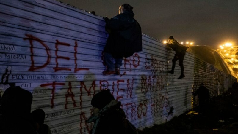 Am ersten Tag des Jahres kletterten zahlreiche Migranten über einen Zaun an der US-mexikanischen Grenze. (Bild: AFP)