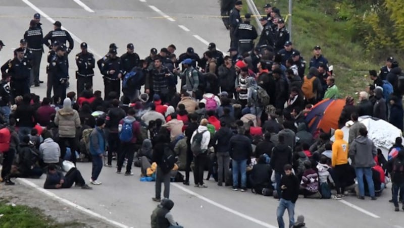 Migranten, die in Bosnien von der Polizei angehalten werden (Bild: AFP, krone.at-Grafik)