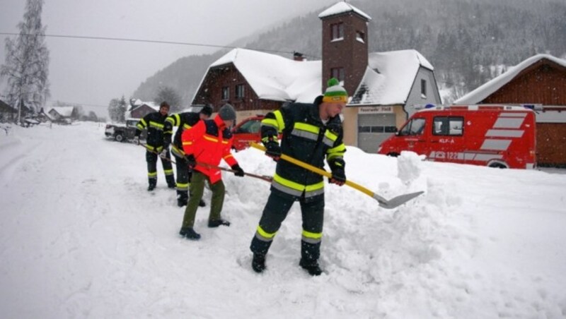 Feuerwehrleute halten vor dem Rüsthaus in Fleiß die Wege frei. (Bild: Matthias Wagner)